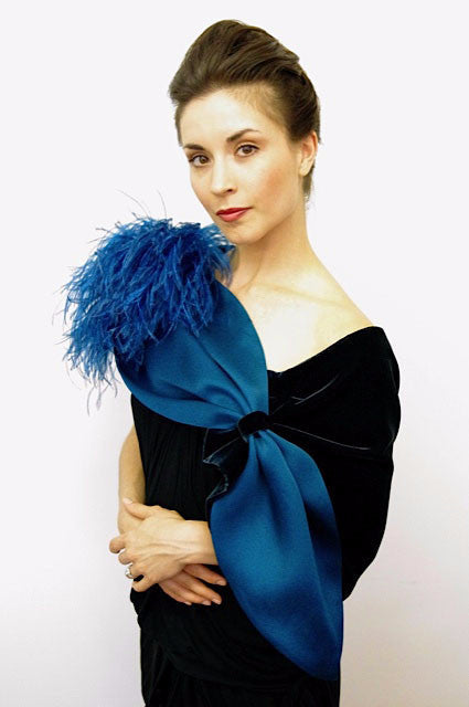 Blue elegant evening wrap measures 60"x 14" . It is made of satin organza and metallic silk organza with pleating detail and ostrich feathers at the shoulder. It is adjustable via a loop closure and fits most, but can be customized to fit larger sizes. Available in teal (shown), black, white, red, royal and grey this eye catching wrap will turn your dress into a couture outfit..