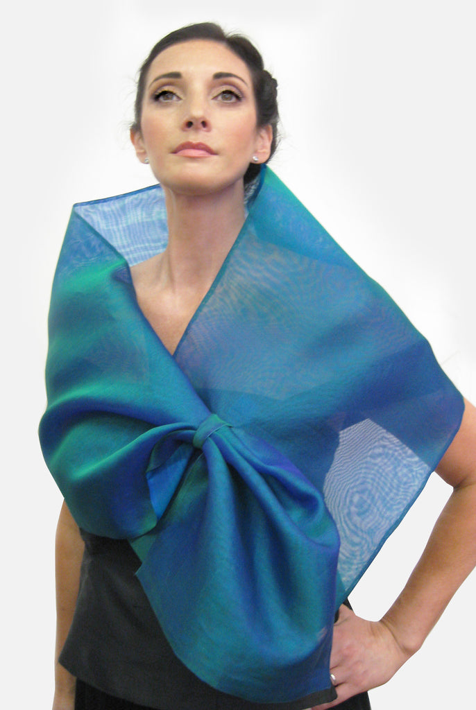 A blue silk organza wrap with a loop closure for easy adjustment and may be worn as a wrap or scarf.  Simple, elegant and dramatic, it creates different looks by pulling the piece through the loop.