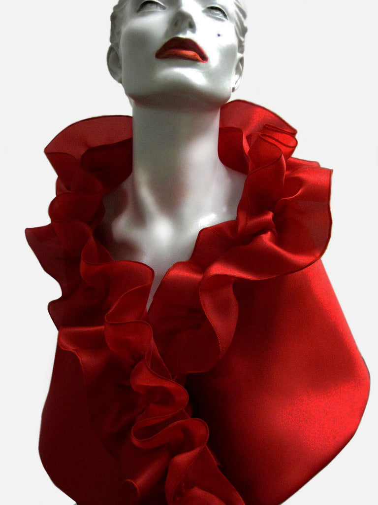 This is a red satin faced organza evening wrap with a rouched collar and a snap closure.