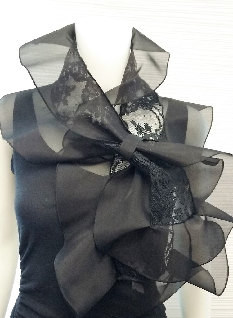 Lace scarf with organza ruffle and loop closure for easy adjustment; available in black, white, cream, or black with pink ruffle;  measurements: 45" x 11"