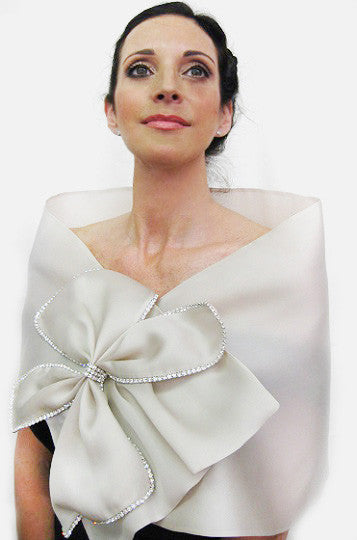 A cream  satin faced organza bridal bow wrap with rhinestone bow trimmings and snap closure;