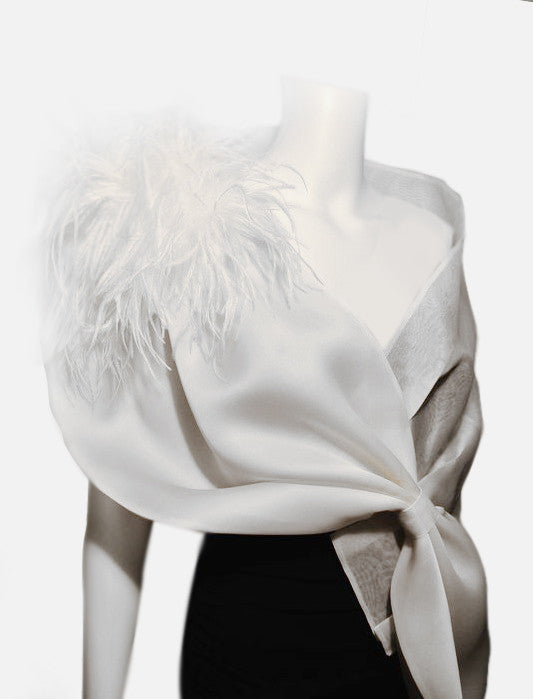 "This elegant evening wrap (Style OSO) measures 63"x 15" . It is made of satin organza and metallic silk organza with pleating detail and ostrich feathers at the shoulder. It is adjustable via a loop closure and fits most, but can be customized to fit larger sizes. Available in white or cream, this eye catching wrap will turn your dress into a couture outfit.