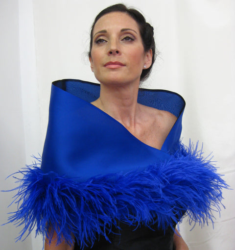 This is a 100% silk evening wrap made of satin faced organza and lined with silk organza. It features ostrich feathers at the border, a tie closure and measures 49" x 13' but can be customized for larger sizes. Available in several colors, it is a bold, dramatic statement piece for your special occasion.